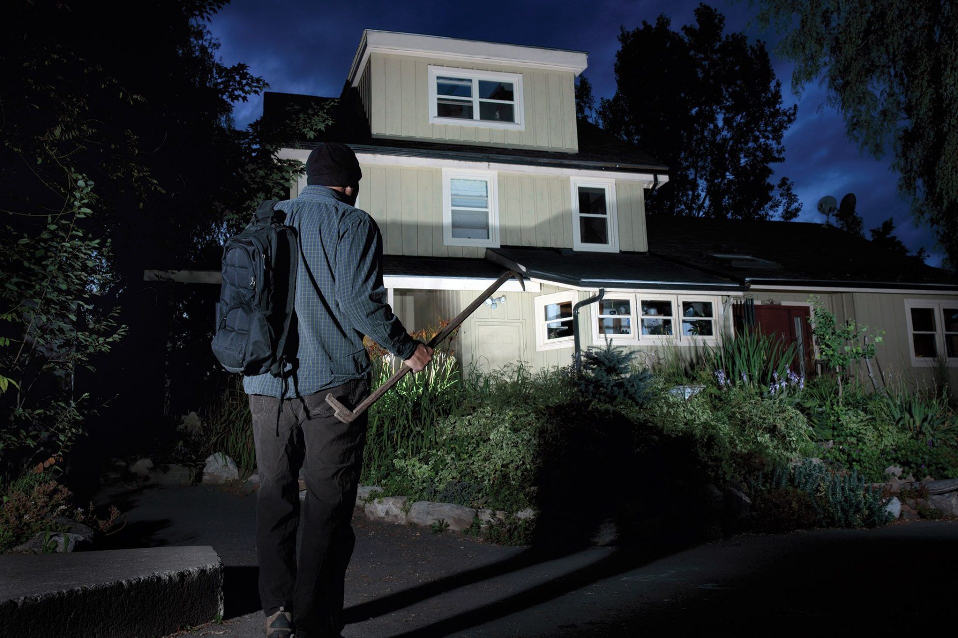 Calm homeowner checking the lock on her front door at dusk